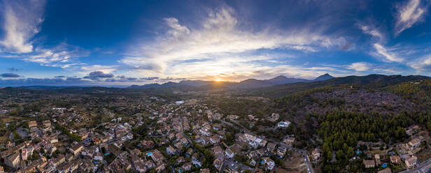 Spain, Mallorca, Calvia, Helicopter panorama of old town at sunset with Serra de Tramuntana range in background - AMF08498