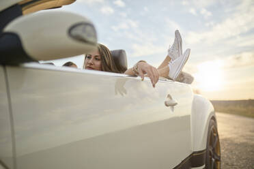 Niedriger Ausschnitt einer Frau mit ihren Freunden, die sich in einem Cabrio entspannen - ZEDF03812