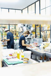 Köche beim Kochen in einer Großküche eines Restaurants, gesehen durch ein Fenster - PGF00043