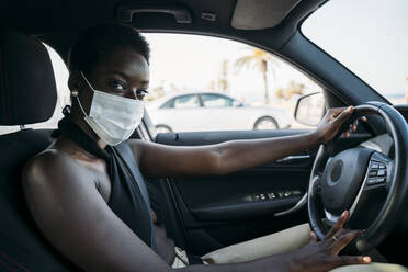 Frau mit Gesichtsschutzmaske beim Autofahren - MPPF01099