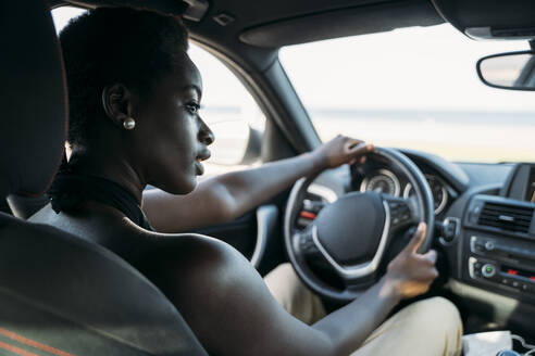 Schöne Frau schaut beim Autofahren weg - MPPF01101