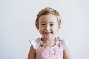 Lächelnd Baby Mädchen stehend gegen weiße Wand - EBBF00765