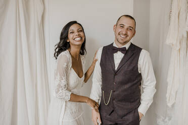 Bride and bridegroom smiling while standing at home - SMSF00333