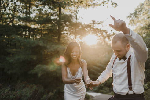 Paar genießt beim Tanzen im Wald bei Sonnenuntergang - SMSF00352