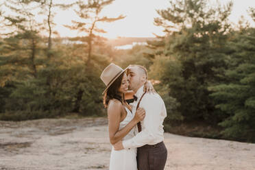 Paar küsst sich bei Sonnenuntergang auf einem Gehweg im Wald - SMSF00364