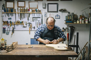 Handwerker bei der Herstellung einer Gitarre in der Werkstatt - DGOF01476