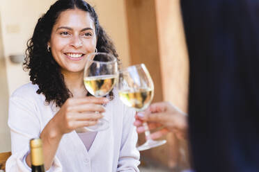 Frauen stoßen mit Weingläsern an, während sie im Hinterhof zu Mittag essen - FMOF01092