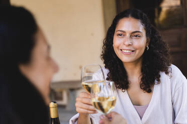 Glückliche Freunde trinken Wein beim Mittagessen im Hinterhof - FMOF01093