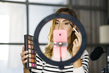 Frau unterrichtet Make-up per Videoanruf, während sie zu Hause sitzt - JSMF01758