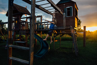 Kleiner Junge auf Spielplatz bei Sonnenuntergang - CAVF89500