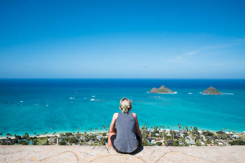 Girl staring at the ocean from on top of a bunker in hawaii - CAVF89513