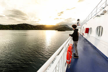 Teenager auf einem Boot auf dem Weg zwischen den Inseln in Neuseeland - CAVF89535