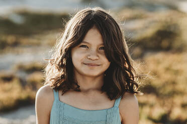 Young girl with brown eyes and thick dark hair wearing blue tank top - CAVF89555