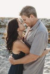 Mid-40's man and woman with closed eyes embracing and touching noses - CAVF89566