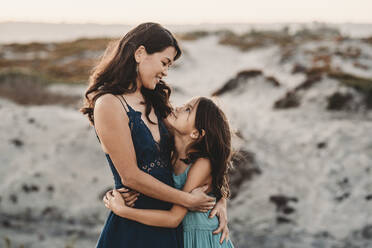 Glückliche Mutter, die ihre 8 Jahre alte Tochter am Strand umarmt - CAVF89582