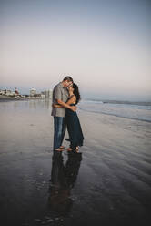 Barefoot loving mid-40's couple on beach embracing face to face - CAVF89587