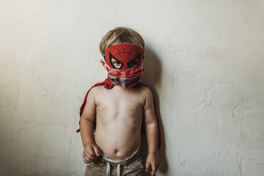 Kleinkind in Halloween-Kostüm und Gesichtsmaske stehend - CAVF89612