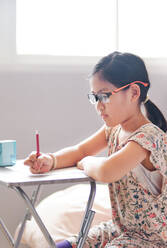 Das Mädchen konzentriert sich während der Heimschule auf ihre Arbeit - CAVF89630