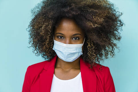 Woman wearing protective face mask standing against wall stock photo
