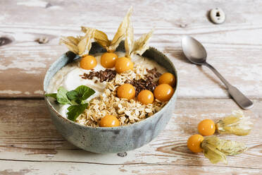 Bowl of porridge with oats, flax seed and winter cherries - EVGF03764