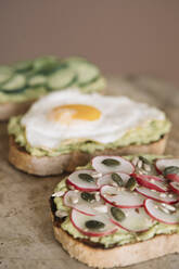 Brown bread garnished with guacamole and vegetables on serving dish at kitchen - ALBF01555