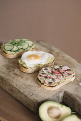 Bread garnished with fresh vegetable and guacamole on serving dish at kitchen - ALBF01559