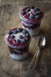 Cups of blueberry buckwheat porridge topped with blueberry on table - EVGF03776