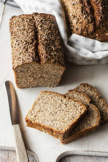 Laib und Scheiben Schwarzbrot auf dem Schneidebrett - EVGF03791