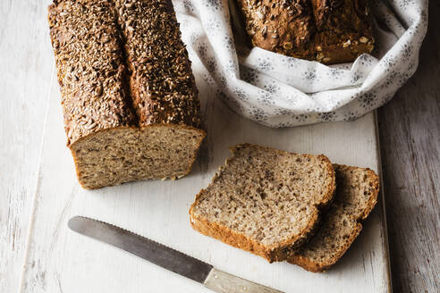 Selbstgebackenes Buchweizenbrot und aufgeschnittene Scheiben auf dem Schneidebrett - EVGF03792