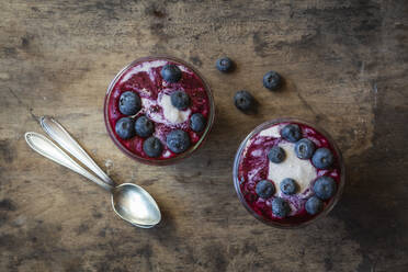 Cups of blueberry buckwheat porridge with blueberry topping on table - EVGF03805