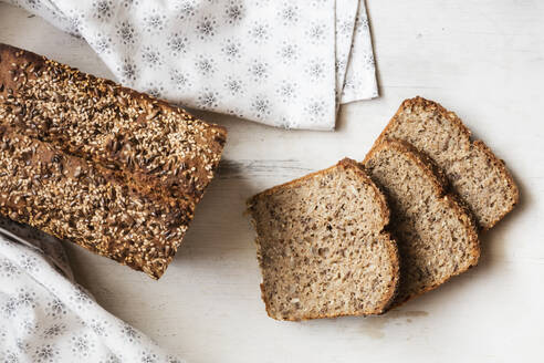 Buchweizenbrotlaib mit aufgeschnittenem Brot auf dem Tisch - EVGF03809