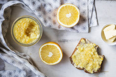 Orangenscheibe und hausgemachte Marmelade mit Brot und Butter auf dem Tisch - EVGF03811