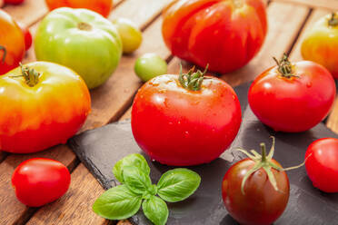 Variety of organic tomatoes on wooden table - ADSF15801