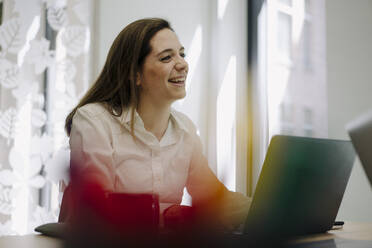 Geschäftsfrau lächelnd bei der Verwendung eines Laptops im Büro - JOSEF02005