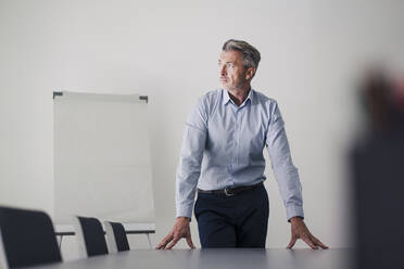 Geschäftsmann mit Händen auf Tisch stehend im Sitzungssaal im Büro - JOSEF02065