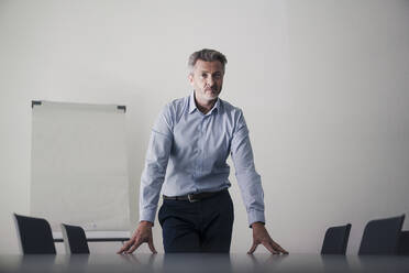 Mann stehend mit Händen auf Tisch im Sitzungssaal im Büro - JOSEF02066