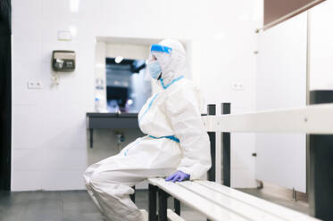 Healthcare man sitting on bench in medical room at hospital - PGF00111