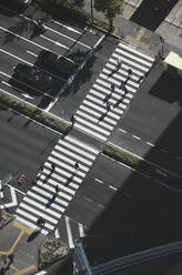Aerial view pedestrians crossing city street at crosswalk, Tokyo, Japan - FSIF05154