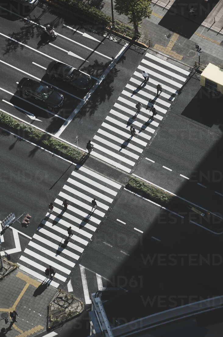 Aerial view pedestrians crossing city street at crosswalk, Tokyo 