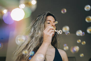 Young woman blowing bubbles - FSIF05158