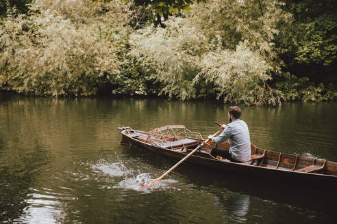 Man rowing canoe on tranquil River Avon, Bath, Somerset, UK - FSIF05189