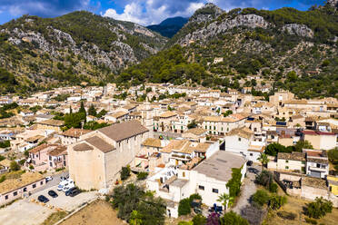 Luftaufnahme von Häusern in einem Dorf gegen eine Bergkette an einem sonnigen Tag, Caimari, Mallorca, Spanien - AMF08521