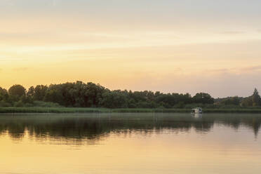 Fernblick auf ein Hausboot im See bei Sonnenuntergang - MMAF01391