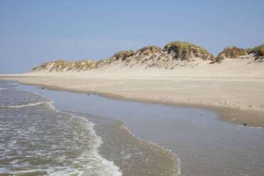 Landschaftlicher Blick auf den Strand mit Dünen vor blauem Himmel an einem sonnigen Tag - WIF04330