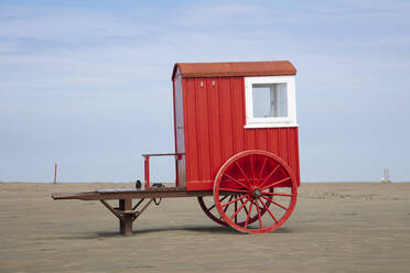 Red bathing cart on sand at beach against sky - WIF04335