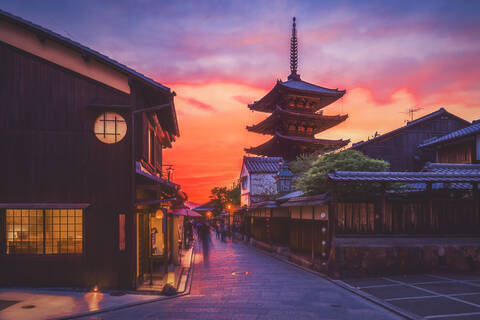 Ancient temple by traditional street against cloudy sky during sunset, Kyoto stock photo
