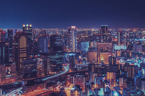 Beleuchtete moderne Gebäude in der Stadt bei Nacht, Osaka, lizenzfreies Stockfoto