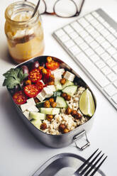 Lunchbox mit frischem veganem Salat auf dem Schreibtisch vor der Computertastatur - IPF00550