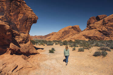 Woman exploring Valley of Fire State Park in summer, Nevada, USA - DGOF01536