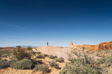 Frau im Valley Of Fire State Park vor blauem Himmel, Nevada, USA - DGOF01537